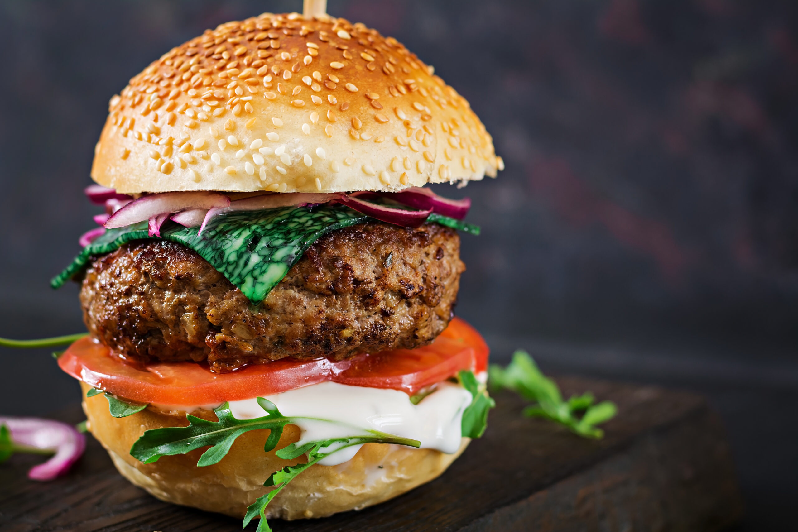 Big sandwich - hamburger burger with beef, tomato, basil cheese and arugula.